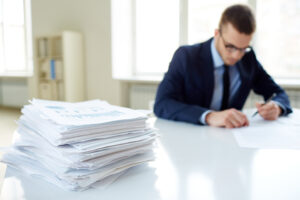 Man sitting next to a stack of mortgage investing documents.